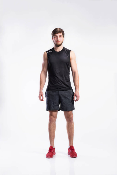 Handsome fitness man in black sleveless shirt, studio shot. - Foto, Imagem