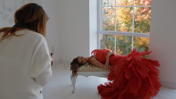 Жорстока жінка в червоній сукні позує в студії
. - Кадри, відео