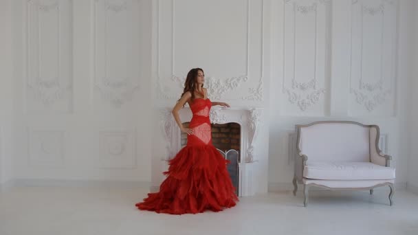 Прекрасная женщина в красном платье позирует в студии
. - Кадры, видео