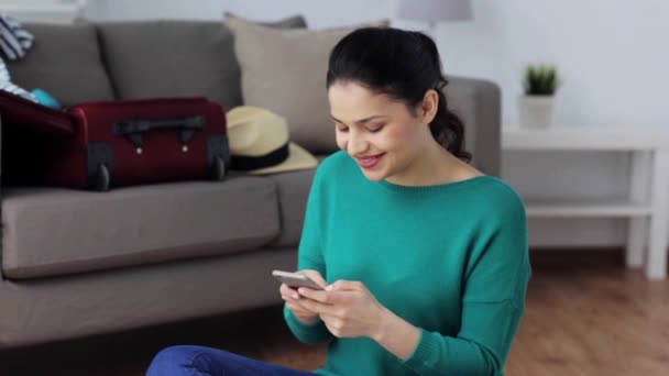 woman with smartphone at home going to travel - Video, Çekim