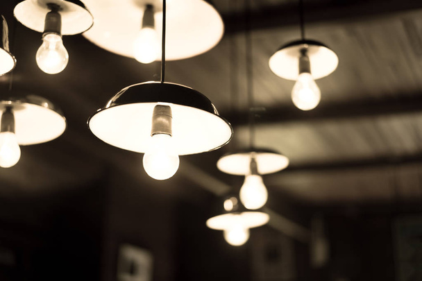 Beaucoup de lampes suspendues au plafond dans une pièce sombre
. - Photo, image