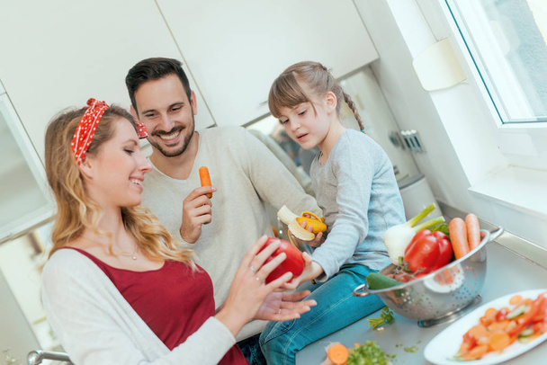 Young family preparing lunch from fresh veggies  - Zdjęcie, obraz