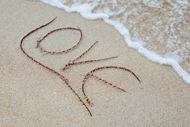 Love word written on the beach by the sea. - Photo, Image