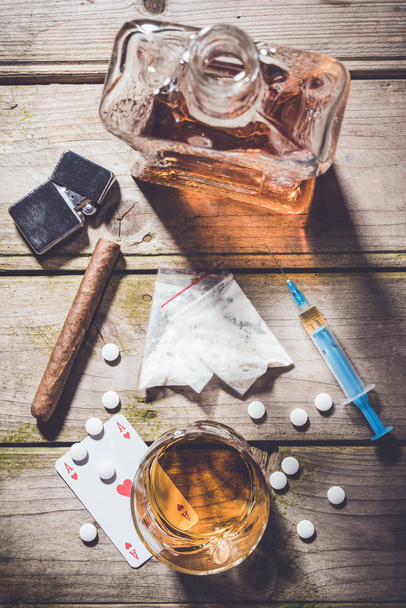 Overhead shot of hard drugs and alcohol on wooden table. - Фото, зображення