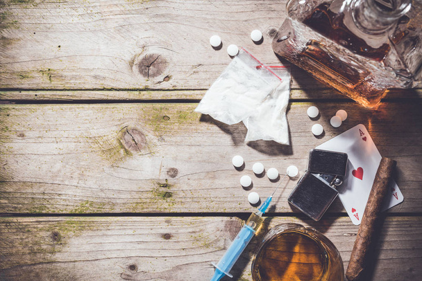 Overhead shot of hard drugs and alcohol on wooden table. - Photo, Image