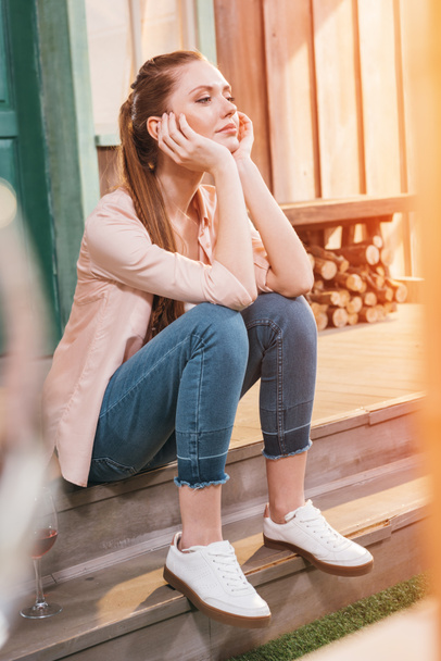 pensive woman sitting on the porch
 - Фото, изображение
