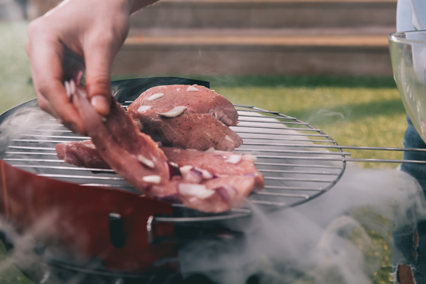 man roasting meat - Foto, afbeelding