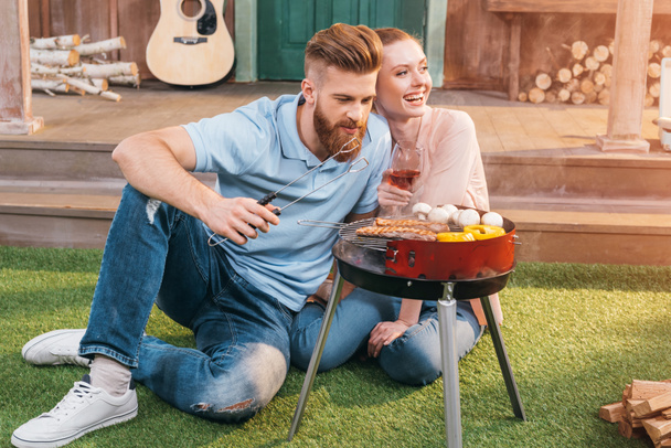 couple grilling meat and vegetables - Photo, Image