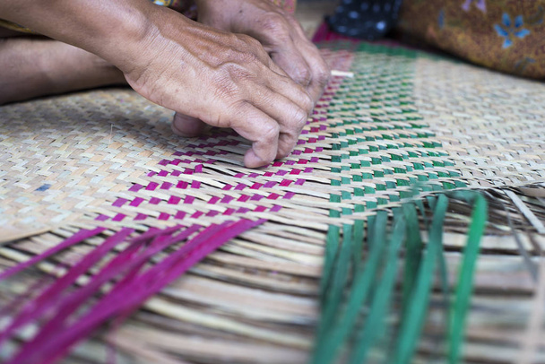 manos femeninas haciendo trabajo de canasta de junco
 - Foto, Imagen