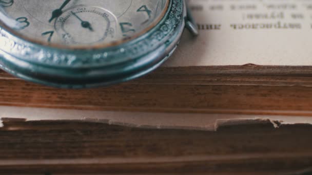 Vintage starožitné kapesní hodinky na pozadí starých knih - Záběry, video