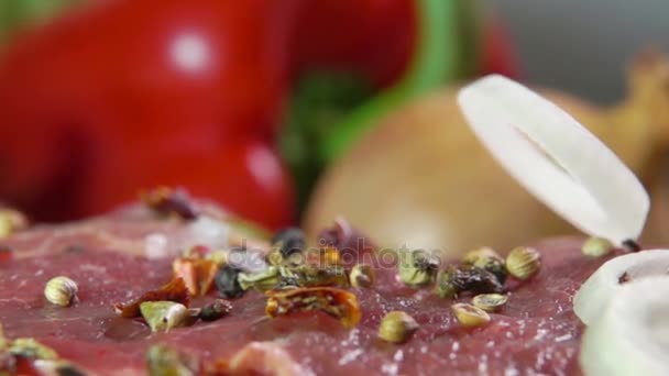 Onion rings falling on a meat beef steak - Materiał filmowy, wideo