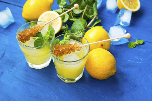 Свіжі лимонадні келихи з цукровими паличками, м'ятною травою та кубиком льоду
 - Фото, зображення
