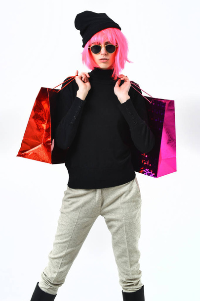 fashionable sexy girl in pink wig holding package or bags - Foto, afbeelding