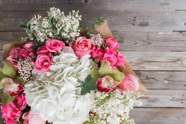 Luxe boeket van verschillende bloemen in glasvaas op houten muur. Kopiëren van ruimte - Foto, afbeelding