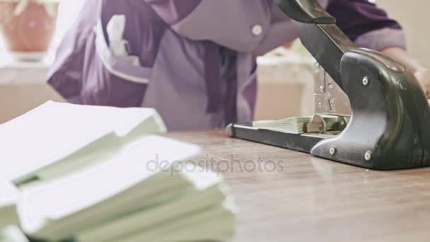 Kobieta o typografii dziurkuje w przemyśle poligraficznym papier opakowania, pracy ręcznej - Materiał filmowy, wideo