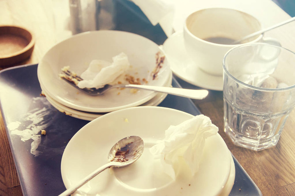 Βρώμικα πιάτα κουταλιά πιρούνι τσαλακωμένο χαρτοπετσέτες στο τραπέζι στην καφετέρια - Φωτογραφία, εικόνα