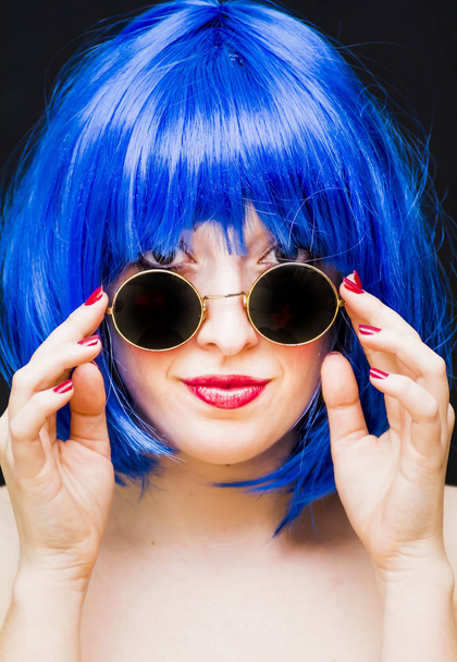 Mulher beleza com azul Wig e óculos de sol sobre fundo preto
 - Foto, Imagem