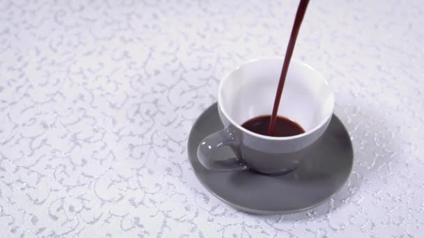 カップが白い模様のテーブル クロスの上に立つ、コーヒーはそれに注がれる - 映像、動画