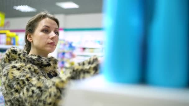 Nainen shoppailee kaupassa kodin kemikaaleja ja kosmetiikkaa
 - Materiaali, video