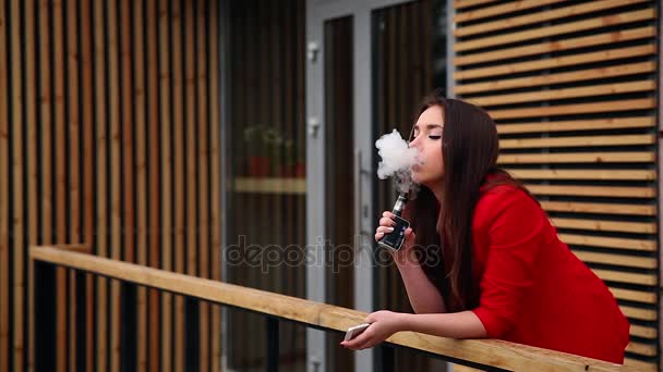 jovem morena espetacular fora usa cigarro eletrônico elegante e saudável
 - Filmagem, Vídeo