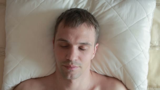 A man sleeps on the bed with a restless sleep. Sharply opens his eyes, looks into the camera and screams in fright. Close-up. View from above - Filmagem, Vídeo