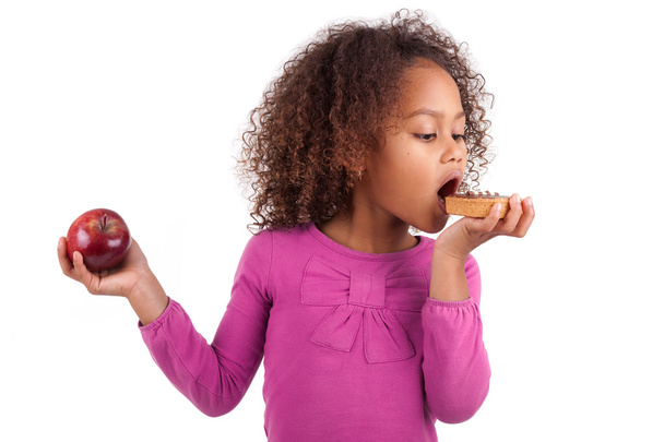 Little African Asian girl eating a chocolate cake - 写真・画像
