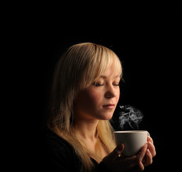 young blond hair woman with coffe on a dark background - Photo, Image