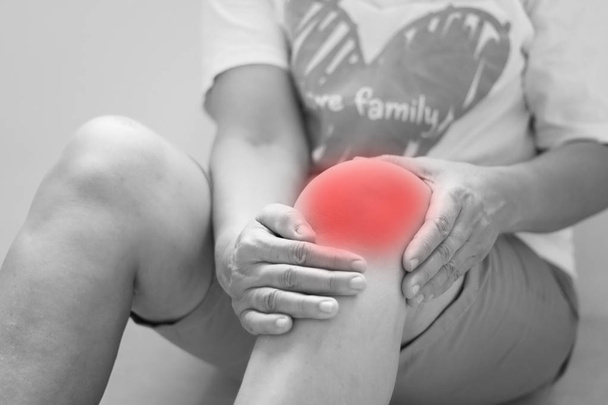 Enfoque suave de las mujeres asiáticas de edad a la lesión de rodilla sobre fondo blanco
 - Foto, Imagen