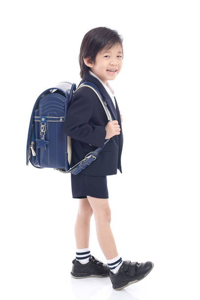 Asian child in school uniform with blue school bag  - Фото, изображение