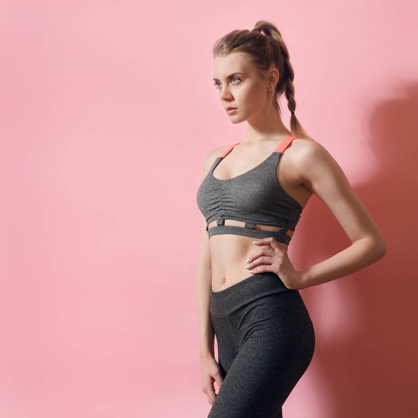 Fitness model woman focused on sport goals. Beautiful woman wearing sport clothes posing. - Fotó, kép