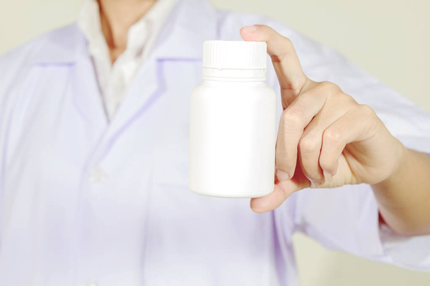 το χέρι του γιατρού κατέχει ιατρική μπουκάλι σε λευκό φόντο - Φωτογραφία, εικόνα
