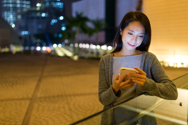 Woman using cellphone at night - Foto, Bild