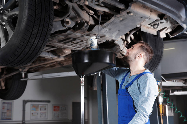 Young mechanic fixing car  - Foto, Bild