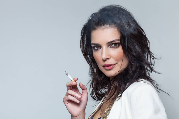 Sensual woman portrait wearing blazer and smoking cigarette - Фото, зображення