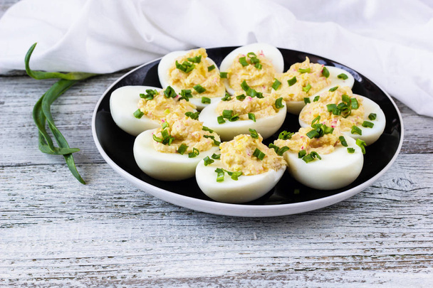 Huevos caseros rellenos de queso y cangrejo rematados con cebolla verde
 - Foto, Imagen