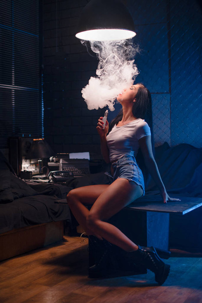 Close-up Retrato de sexy jovem hipster fumar (vaping) menina. Conceito de vapor. Vaping e-cigarro
. - Foto, Imagem