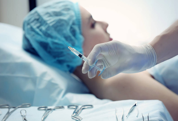 Plastic surgeon's hand holding syringe for facial injection - Foto, immagini
