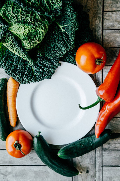 Verse groenten: boerenkool, wortel, paprika, tomaat, komkommer rond  - Foto, afbeelding