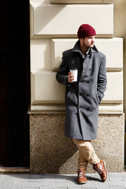 Uomo in cappello rosso con caffè per strada
  - Foto, immagini