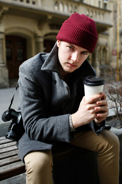 Man in red hat with coffee on the street  - 写真・画像