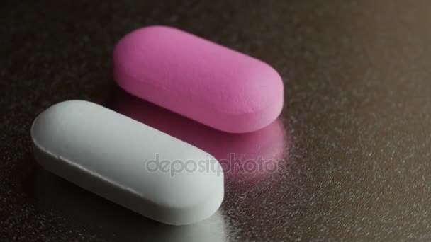 Gyógyszer- és kábítószer. Két tabletta bekapcsolása a háttér. - Felvétel, videó