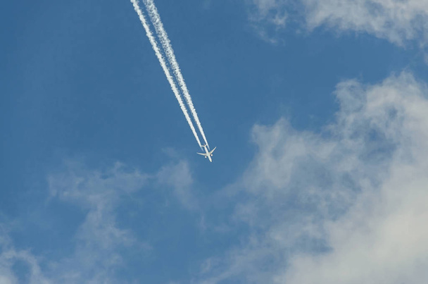Літак з реакційною стежкою, що літає над блакитним небом з хмарами
 - Фото, зображення