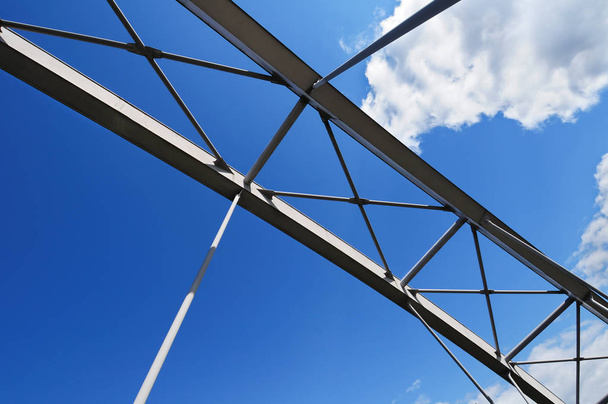 Сучасний зв'язаний арковий міст проти похмурого блакитного неба
 - Фото, зображення
