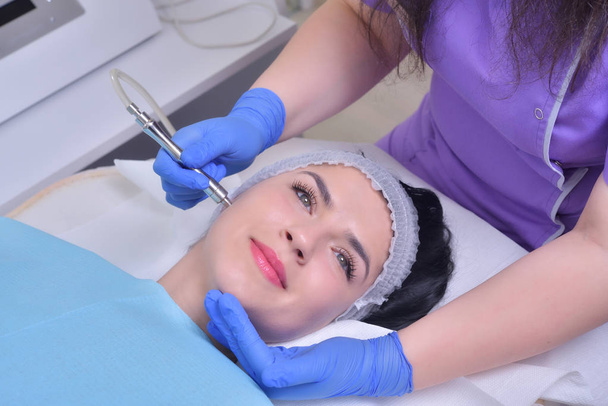 Νεαρή όμορφη γυναίκα παίρνει επαγγελματικό ατού δέρμα του προσώπου θεραπεία σε κλινική ομορφιάς - Φωτογραφία, εικόνα