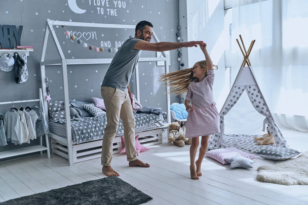 father and daughter dancing in bedroom - Foto, afbeelding