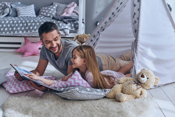 little girl reading book with father - Foto, imagen