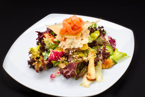 salade chaude de poisson, légumes sur une assiette blanche
 - Photo, image
