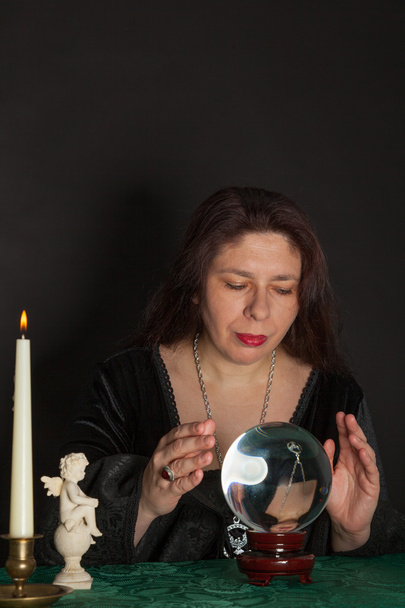 eine Frau blickt in eine Kristallkugel - Foto, Bild