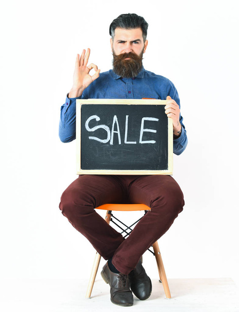 Bearded man, brutal caucasian hipster with moustache holding sale inscription - Фото, изображение