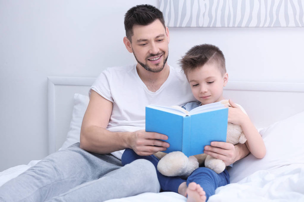 Dad and son reading interesting book  - Photo, image